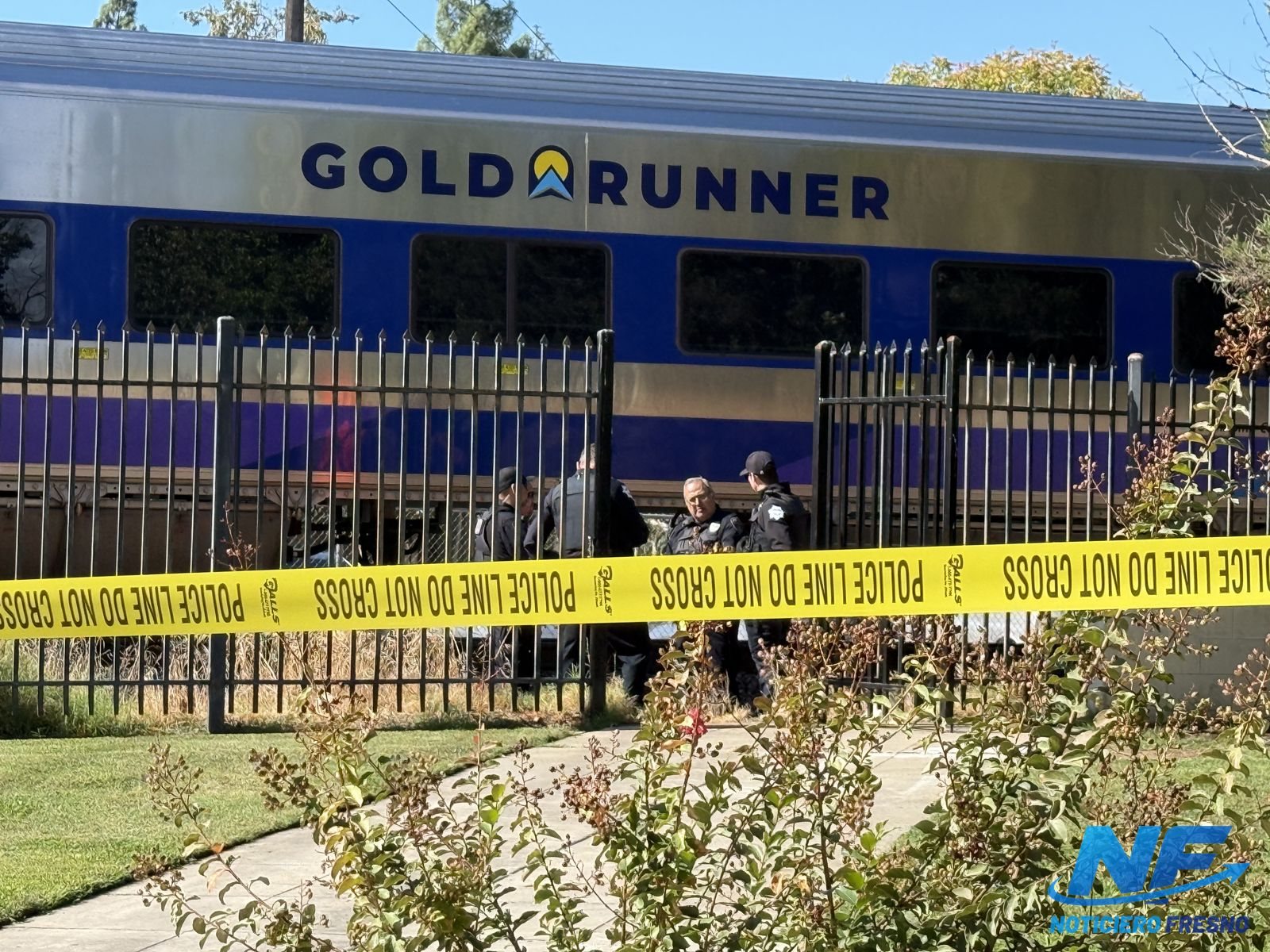 Agentes junto al tren Gold Runner detrás de la cinta policial en la avenida McKinley, junto a Fresno City College